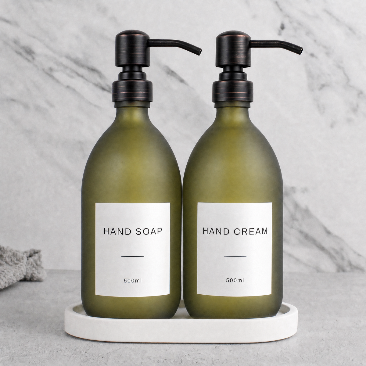White Tray & Frosted Green Glass Hand Soap & Hand Cream Set on a white stone tray, black and copper pumps