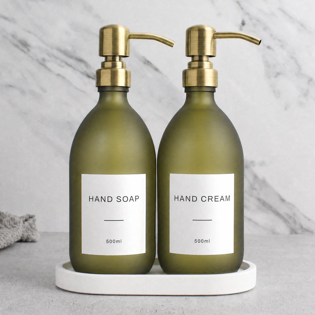 White Tray & Frosted Green Glass Hand Soap & Hand Cream Set on a white stone tray, gold pumps