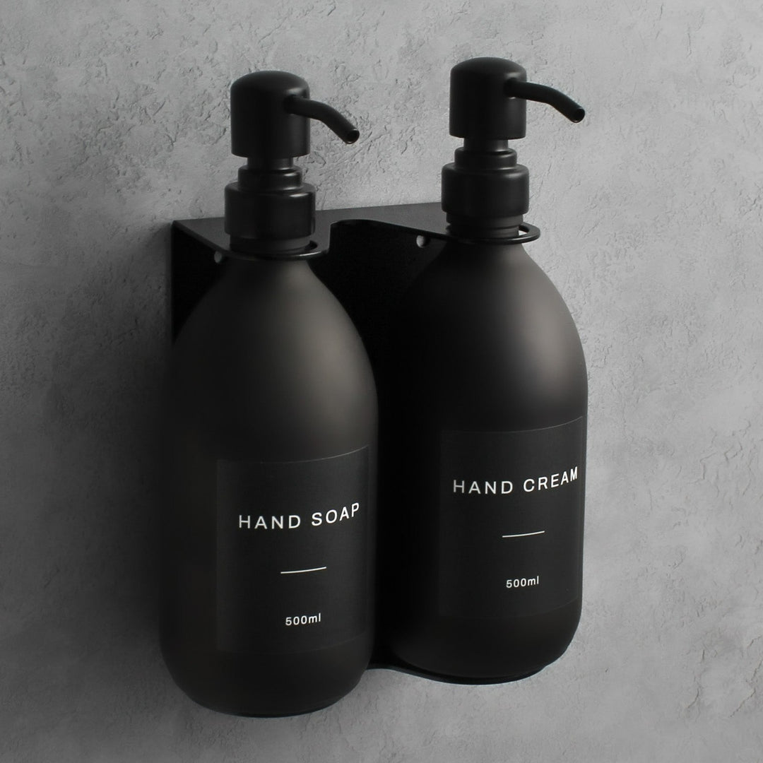 Matte black glass soap dispenser bottle set on metal wall mounted bracket for hand soap and hand cream for hotels, home, spas, cafe, restaurant, b&b