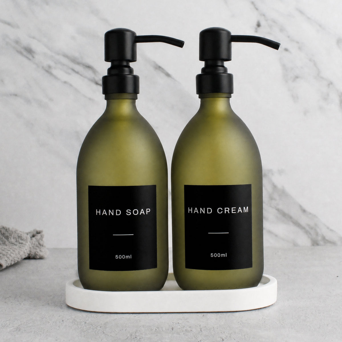 White Tray & Frosted Green Glass Hand Soap & Hand Cream Set on a white stone tray, matte black pumps