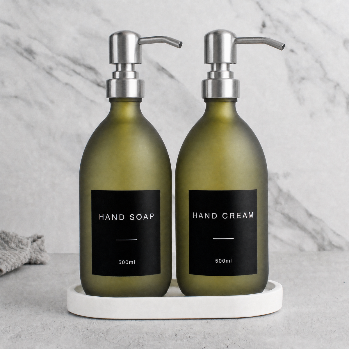 White Tray & Frosted Green Glass Hand Soap & Hand Cream Set on a white stone tray, silver pumps