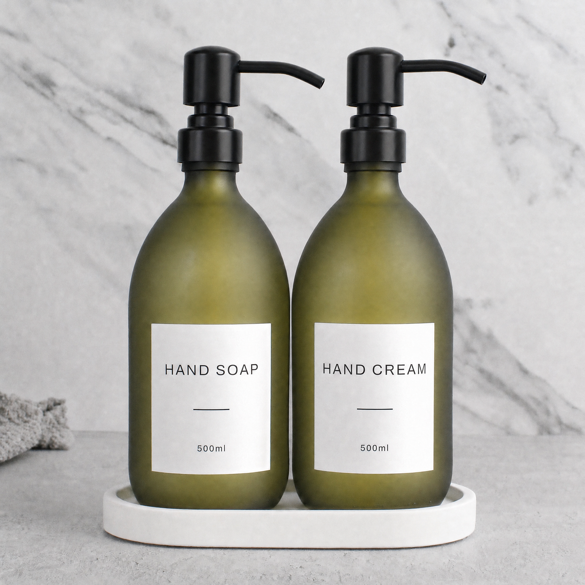 White Tray & Frosted Green Glass Hand Soap & Hand Cream Set on a white stone tray, matte black pumps