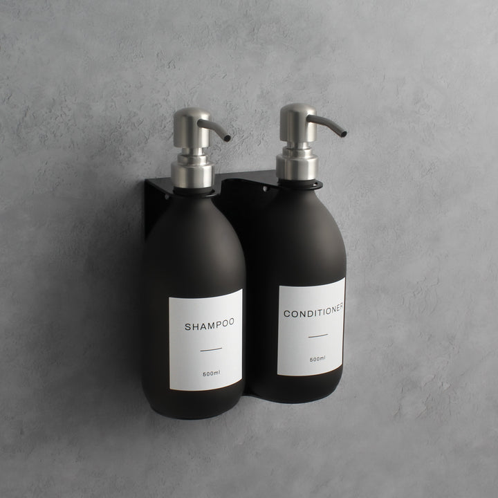 Matte black glass soap dispenser bottle set on metal wall mounted bracket for hand soap and hand cream for hotels, home, spas, cafe, restaurant, b&b